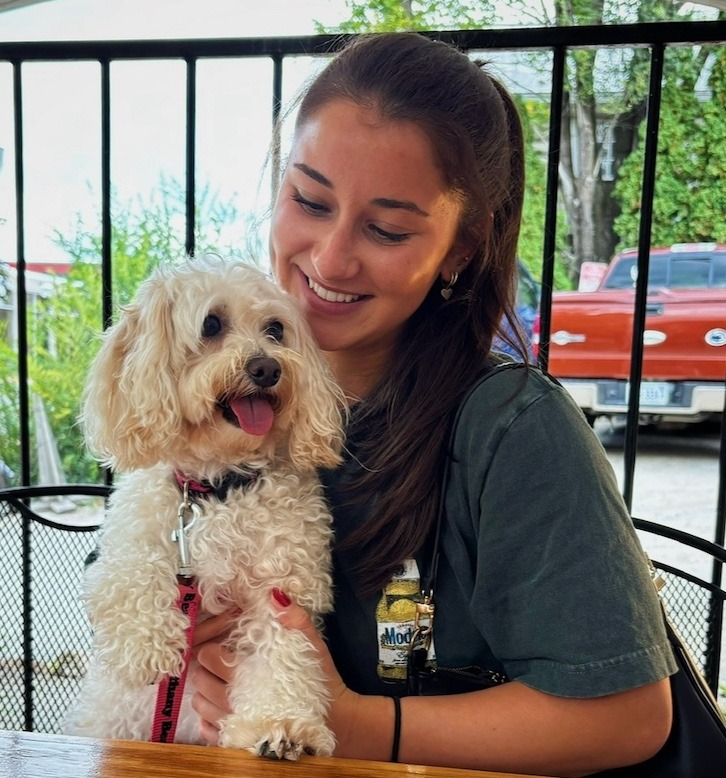 Sarah smiling with a small dog